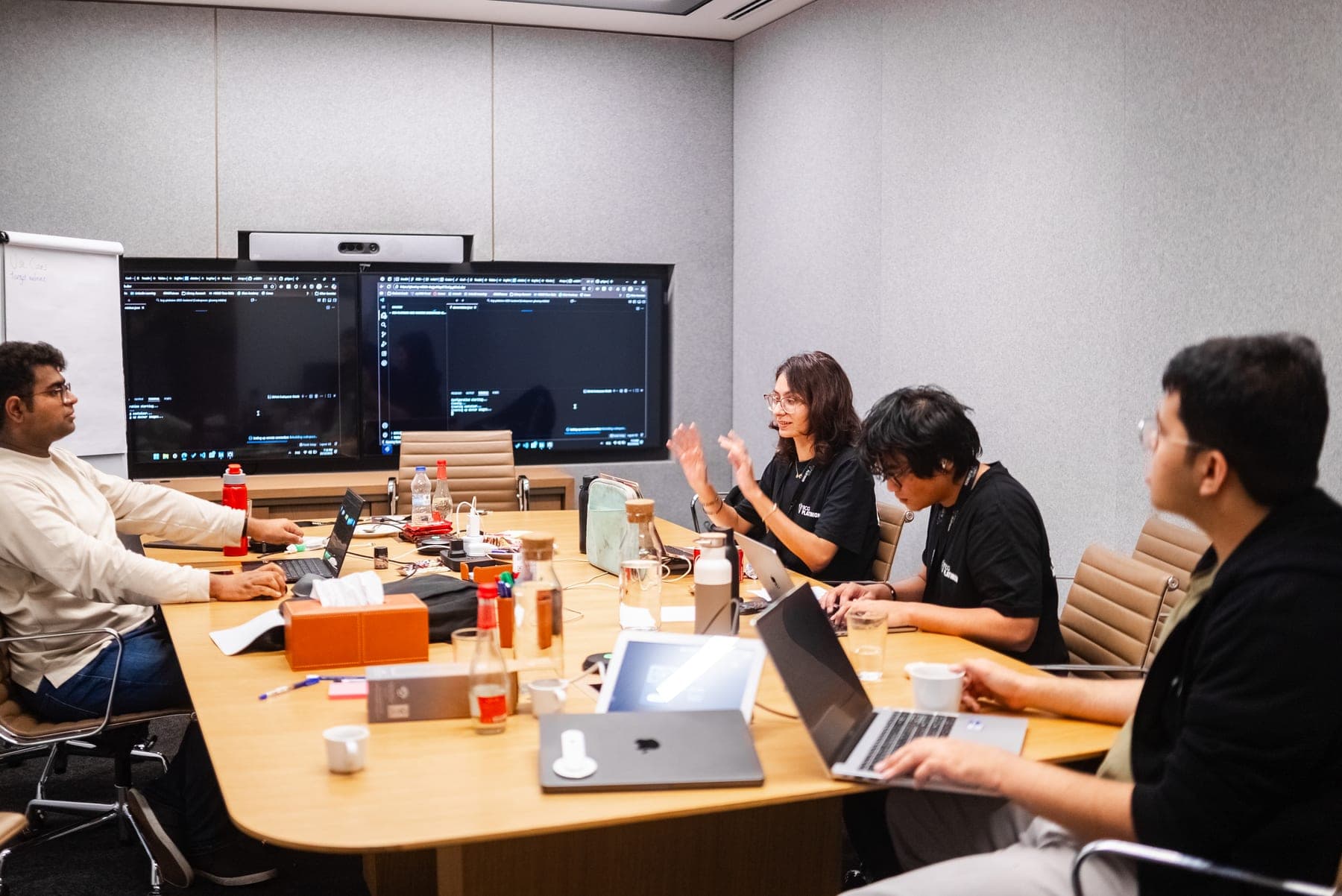 The team mid-build, laptops open and code up on the monitors