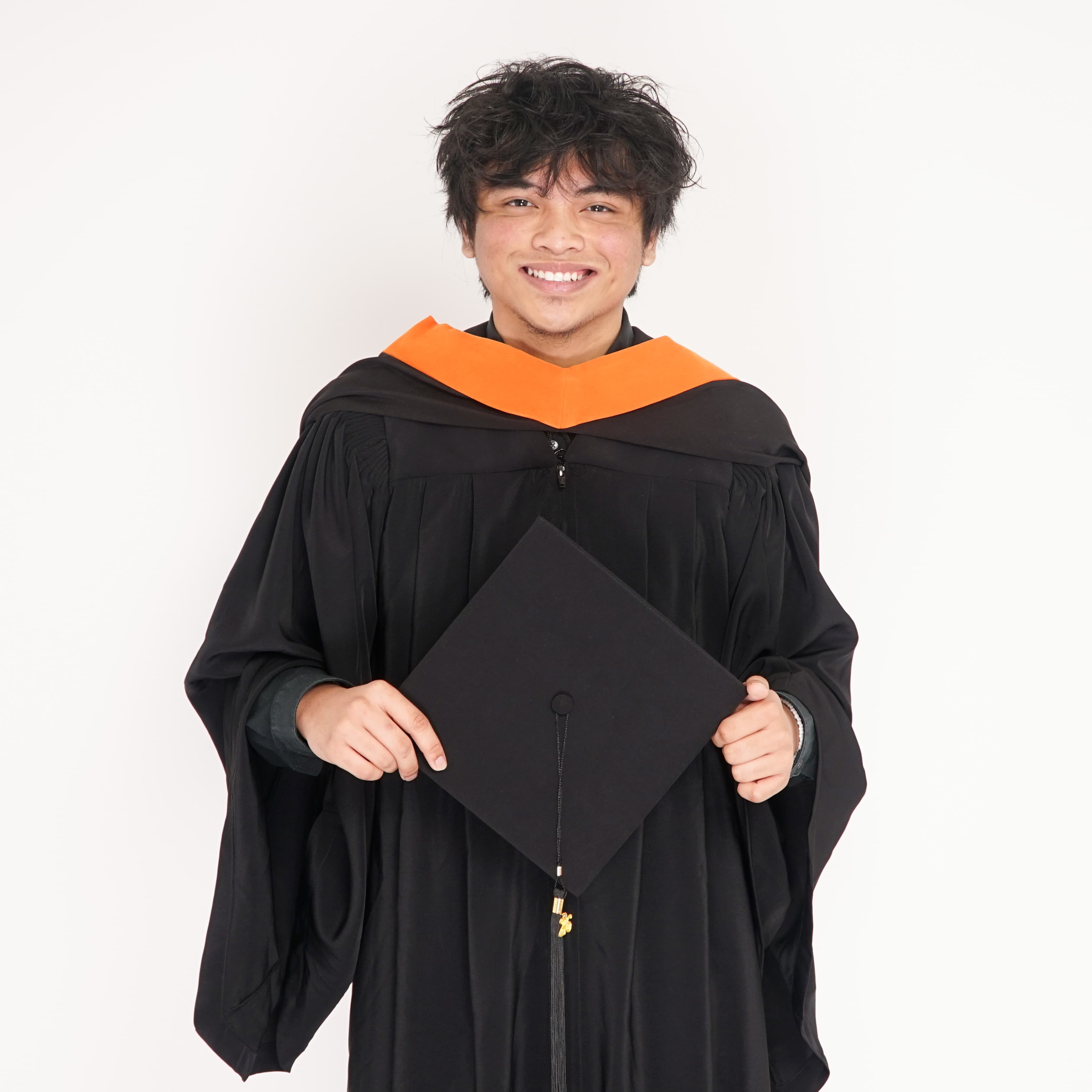Holding my cap, grinning, in the orange-stoled gown right after the ceremony